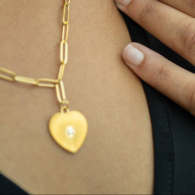 Woman wearing gold jewelry with a blurred natural background