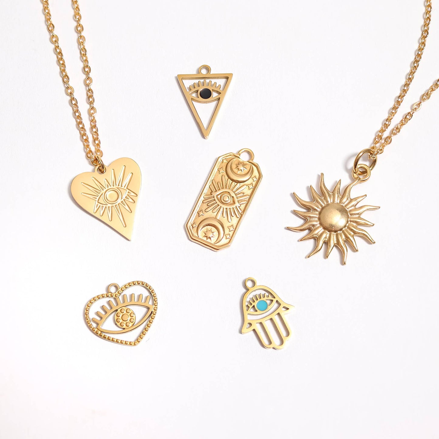 Collection of gold necklaces with various pendants on a white background