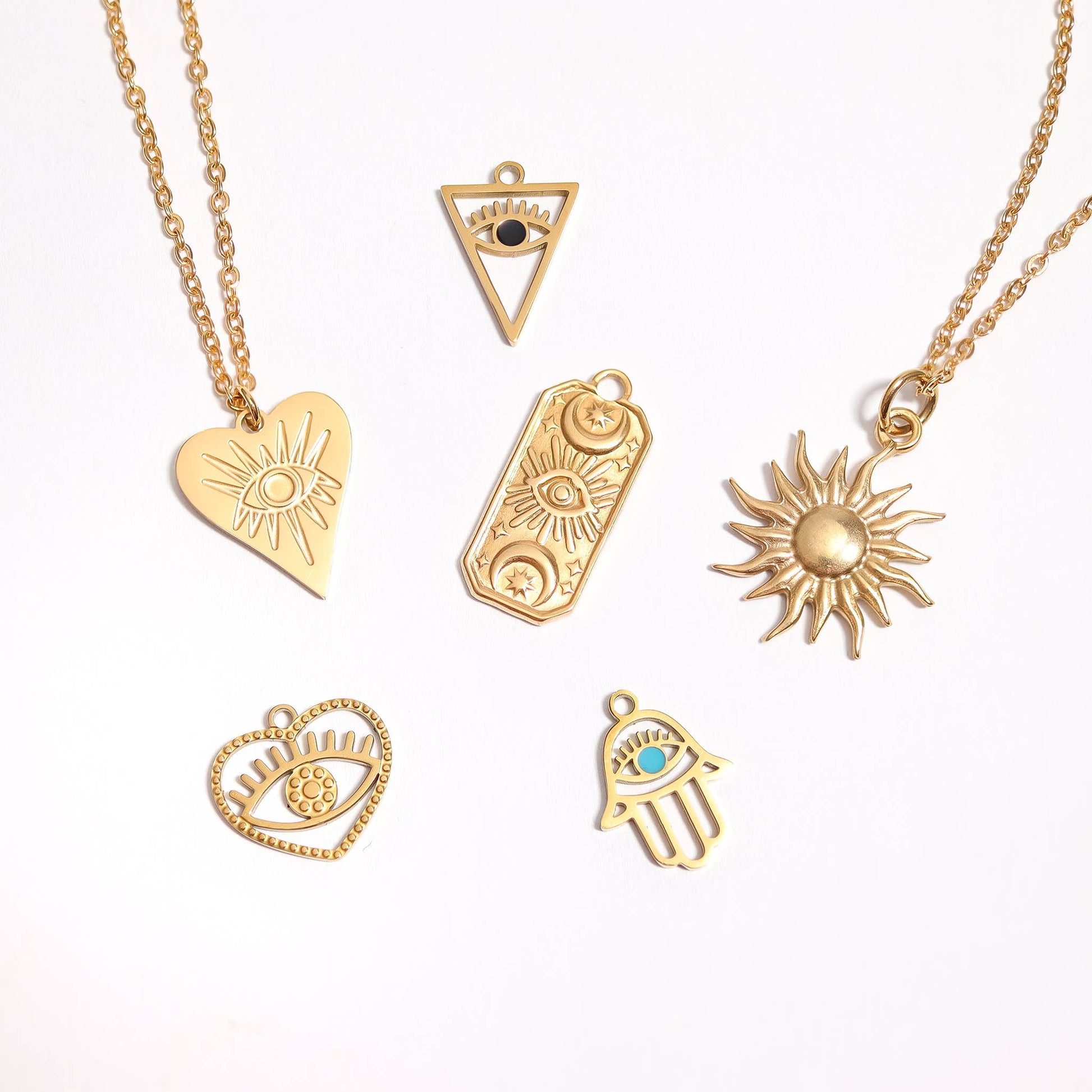 Collection of gold necklaces with various pendants on a white background