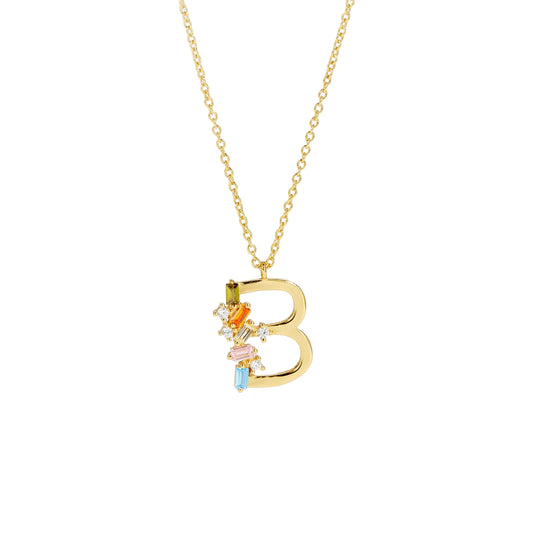Gold necklace with a 'B' pendant featuring colorful stones on a light gray background