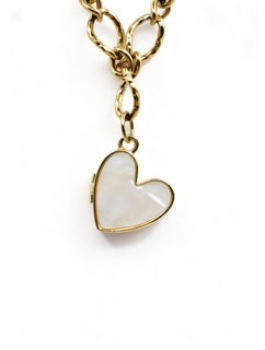 Heart-shaped locket on a gold chain against a white background