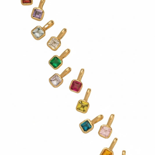Gold pendants with colorful gemstones on a white background