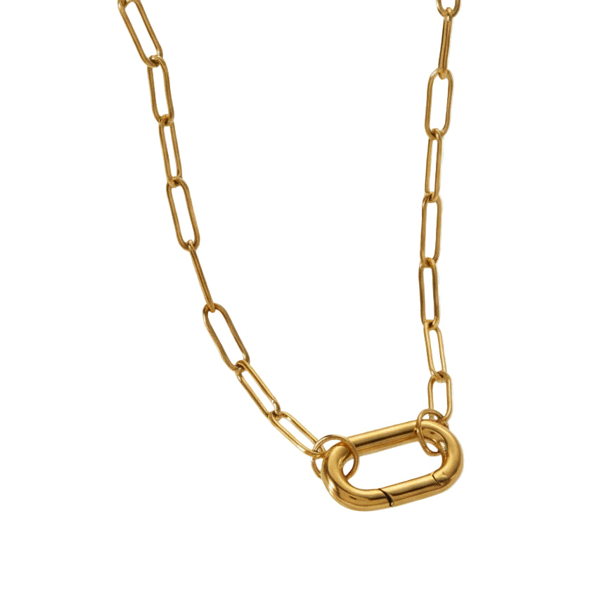 Gold chain necklace on a decorative glass stand with a neutral background