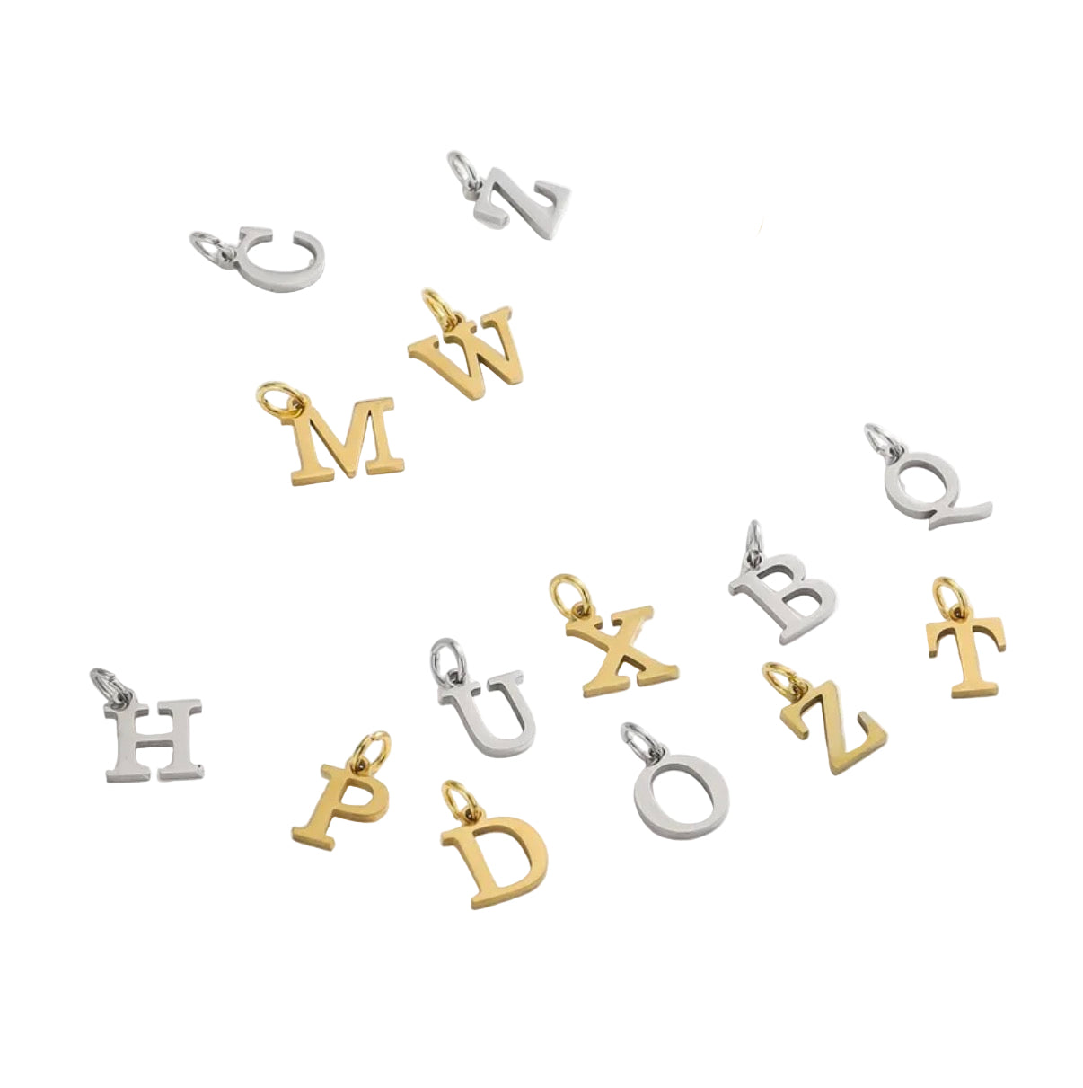 Gold and silver letter pendants on a white surface with dried flowers.