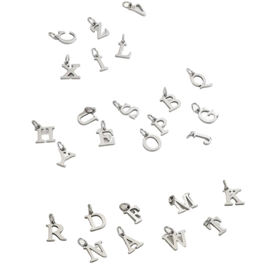 Silver letter pendants on a white fabric background