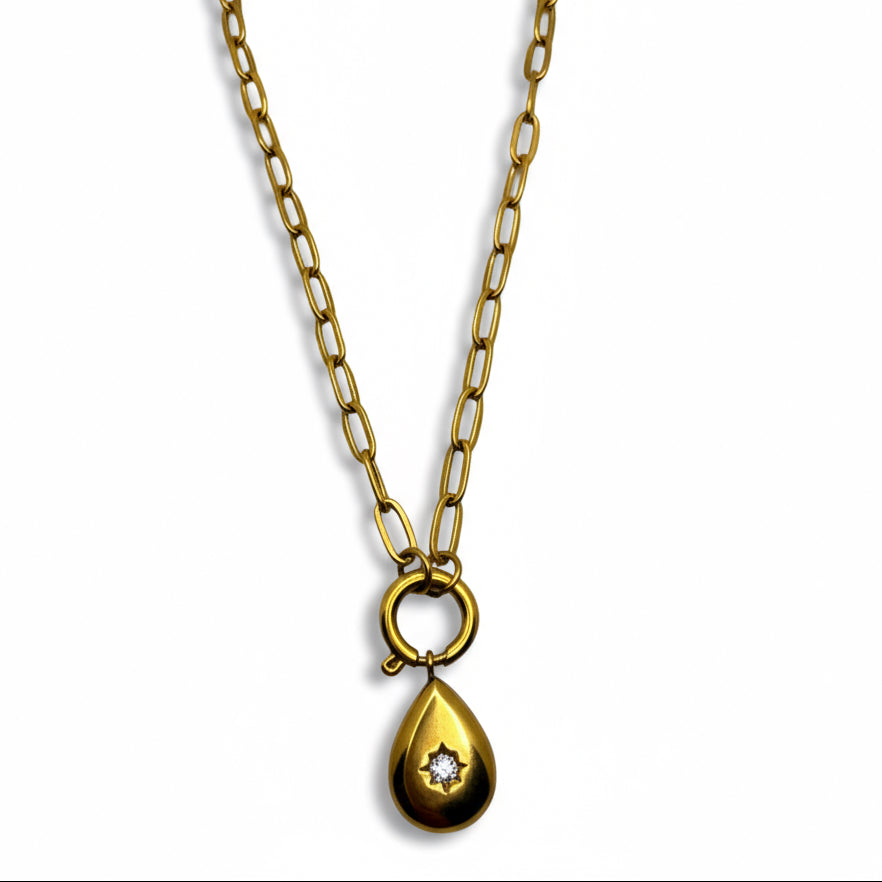 Gold necklace with a teardrop pendant on a light gray background