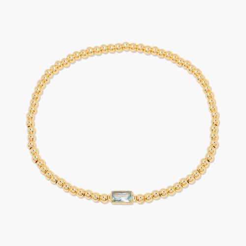 Gold bracelet with a central blue gemstone on a white background