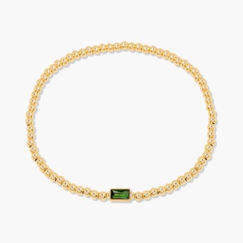 Gold bracelet with a green gemstone on a white background