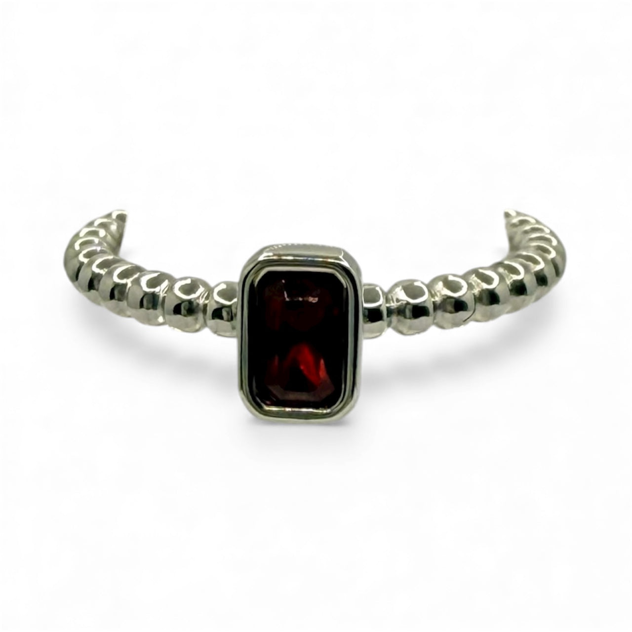 Silver ring with a red gemstone on a white background