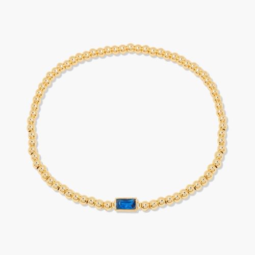 Gold bracelet with a blue gemstone on a white background
